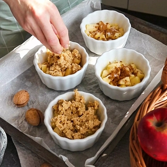 Crumble recept - príprvá - plnenie misiek jablkami a posýpkou